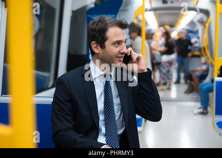 Portrait of businessman talking on son cellulaire pendant qu'il va au travail