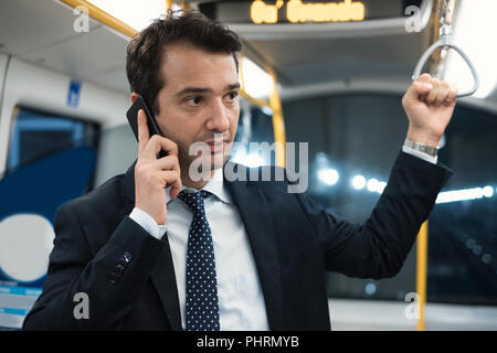 Portrait of businessman talking on son cellulaire pendant qu'il va au travail