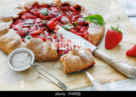 Couper des gâteaux avec des fraises et du basilic. Banque D'Images