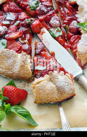 Couper des gâteaux avec des fraises et du basilic. Banque D'Images