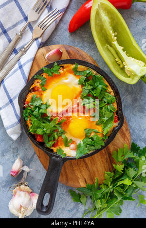Shakshuka. Poêle avec des oeufs dans la sauce tomate. Banque D'Images