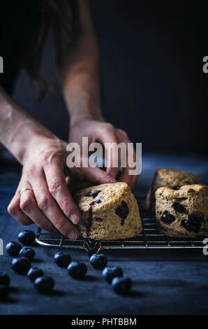 Scones aux bleuets Végétalien sur grille de cuisson avec fond sombre Banque D'Images