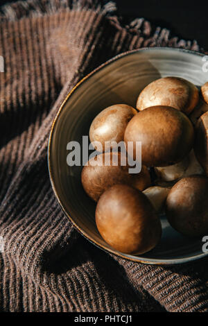 Champignons crus dans un bol sur une table Banque D'Images