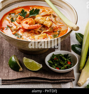 Tom Yam kung soupe de fruits de mer thaï aux crevettes, lait de coco et la citronnelle dans un bol close-up Banque D'Images