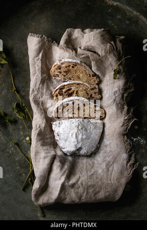 Tranches de gâteau de Noël traditionnel allemand, cuisson festive. Les stollen avec raisins secs et le sucre en poudre sur le linge de maison serviette avec des branches de gui Banque D'Images