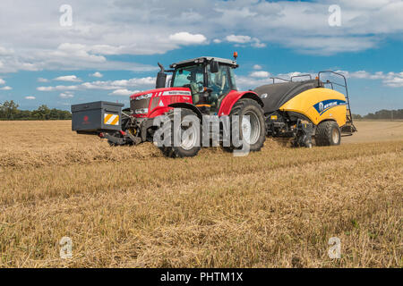 Un tracteur Massey Ferguson 7618 et New Holland 1290 Bigbaler travaillant sur la paille d'orge Banque D'Images