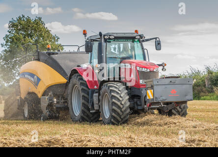 Un tracteur Massey Ferguson 7618 et New Holland 1290 Bigbaler travaillant sur la paille d'orge avec un fini de décharger la balle Banque D'Images