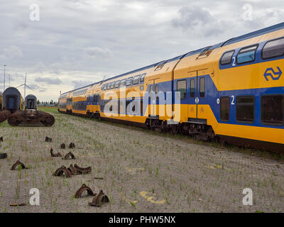 Le train de voyageurs pont double diligences sur les voies de recyclage à Amsterdam, terminal maritime avec Bogies recyclé à côté d'eux. La Hollande. Banque D'Images