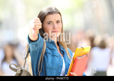 Les étudiants en colère gesturing Thumbs down à la caméra dans la rue à Banque D'Images