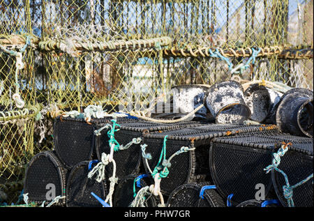Des casiers à crabe et homard avec next stockés sur quai de port de Poole, dans le Dorset, Angleterre et prêt à l'emploi. Banque D'Images