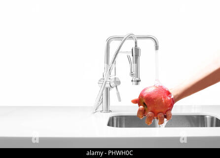 Lave-mains pomme fruit sous le robinet d'eau isolé Banque D'Images