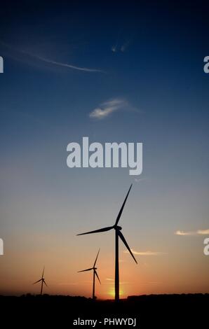 Éoliennes en silhouette sur les terres agricoles au coucher du soleil, Gayton le marais, Lincolnshire, Royaume-Uni Banque D'Images