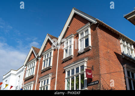 Grand bâtiment en briques rouges avec trois toits et fenêtres avec ciel bleu au-dessus Banque D'Images