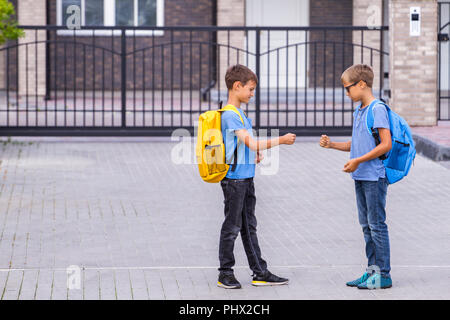 Deux jeunes garçons jouent au jeu Roche-Papier-Ciseaux après l'école Banque D'Images