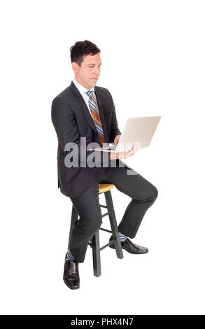 Happy businessman sitting avec son ordinateur portable Banque D'Images