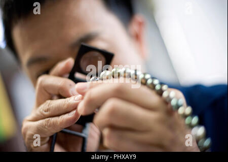 Kazuhito Komatsu Komatsu, président de l'usine de coupe, regarde les perles à facettes traitées à son entreprise dans la ville de Kofu, préfecture de Yamanashi, au Japon, le Banque D'Images