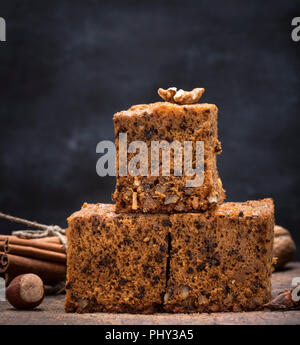 Pile de tranches de carrés au four une tarte aux noix sur une planche en bois brun, un gâteau mousseline Banque D'Images