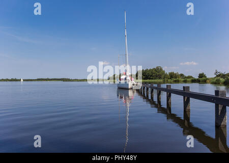 Bateau à bateau sur une jetée dans le Parc National de Weerribben-Wieden, Pays-Bas Banque D'Images