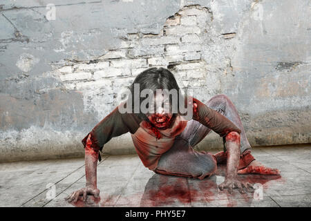 Zombie en colère l'homme avec la bouche sanglante de monter sur mur grunge background Banque D'Images