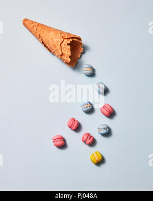 Macarons multicolores et waffle cone présenté sur un fond gris. Mise à plat Banque D'Images