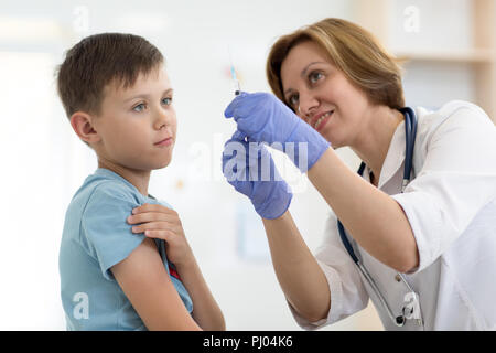 Médecin et patient adolescent seringue détient. Peu de brave garçon avant l'injection. Banque D'Images