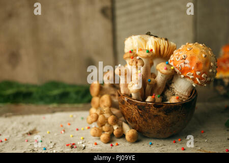 Conte magique partie décor de table, avec des champignons en confiserie tasse sur fond de bois, de l'alimentation toxique poison Banque D'Images