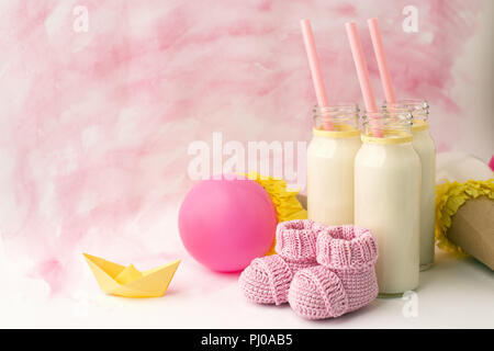 Tableau décoratif de douche de bébé avec copie espace, rose bébé fille combinaison isothermique et bouteilles de lait dans l'arrière-plan de couleur pastel, idée de décoration de douche de bébé Banque D'Images