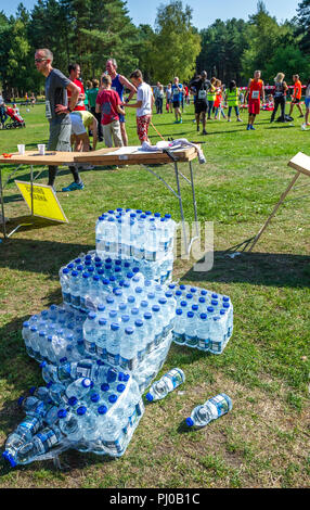 L'eau en bouteille en plastique d'être remis aux coureurs à l'arrivée sur les 2018 Sherwood Pines 10k. Banque D'Images