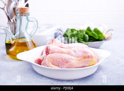 Cuisses de poulet cru avec épinards frais et épices Banque D'Images