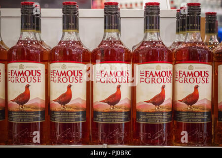 Londres, Royaume-Uni - 12 août 2018 - bouteilles de la Famous Grouse, une marque de blended Scotch whisky sur l'affichage à une boutique hors taxes à l'aéroport Heathrow de Londres Banque D'Images