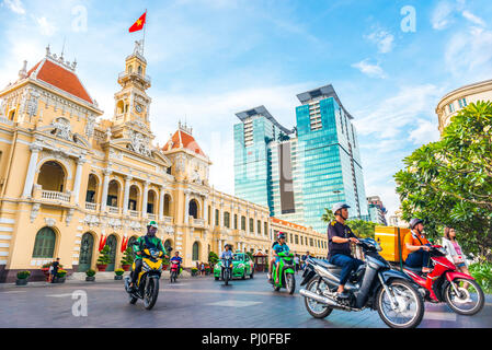 Ho Chi Minh Ville, Vietnam - 30 Avril 2018 : l'Hôtel de ville de Saigon, Centre Vincom Towers, le trafic de rue colorés & plantes tropicales contre le ciel bleu. Banque D'Images