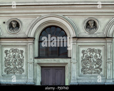 Sur la façade de l'immeuble dans la ville de Saint-Pétersbourg est une fenêtre en arc avec un verre, deux bas-reliefs avec des portraits, un volet sculpture Banque D'Images