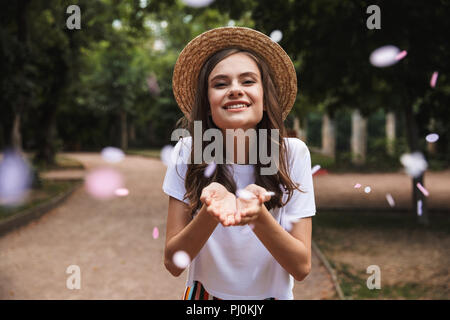 Jeune fille heureuse confettis capture tout en se tenant à l'extérieur du parc Banque D'Images