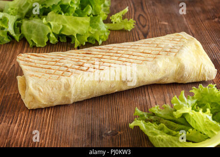 Shaurma. Un plat traditionnel de légumes enveloppés de lavash. Shaurma sur un fond de bois. Banque D'Images