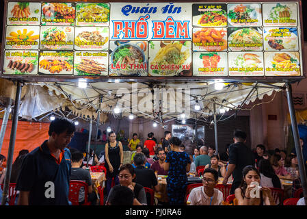 Ho Chi Minh Ville, Vietnam - le 28 avril 2018 : open air nuit street restaurant au marché Ben Thanh. Pancarte affiche le menu avec des photos, les noms des plats Banque D'Images
