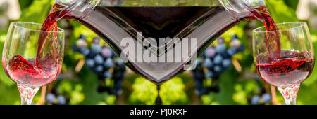 Le vin rouge s'écoule de la fiole dans le verre, sur fond de bleus sur un vignoble. Verser le vin dans le verre de vin. Banque D'Images