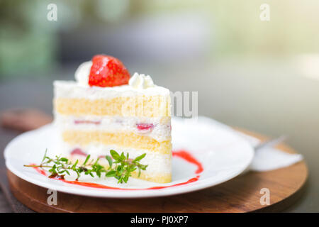 Gros plan du délicieux gâteau aux fraises faites maison avec des fruits et des feuilles sur le dessus de table boulangerie sur fond flou avec copie espace dans la nature, concept de cafe Banque D'Images