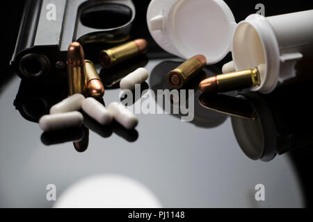 Prescription Pills et des armes sur une table. Balles de mitrailleuses et blanc comprimé gélules de répandre sur une table. Concept de sensibilisation à la santé mentale. Banque D'Images