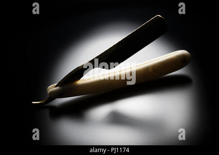 Rasoir droit avec pearl échelles sur un fond noir. Razor Cut Throat, coiffure pour hommes matériel de toilettage. Banque D'Images