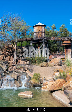 Étang avec de gros rochers et château d'eau en bois sous ciel bleu. Banque D'Images