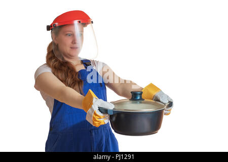 La fille en vêtements de travail et un masque de protection est titulaire d'une casserole à la main, représentant une surprise. Banque D'Images