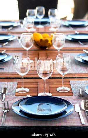 Réglage de la table vin vide avec des verres, assiettes et couverts servis sur une table en bois. Close up de vaisselle, plats, pas de personnes. Préparation pour le dîner Banque D'Images