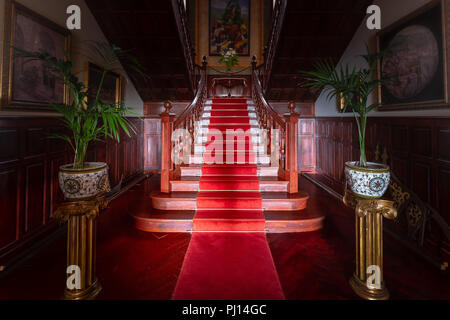 Tapis rouge sur l'escalier en bois dans le vieux palais ou Manor. Banque D'Images