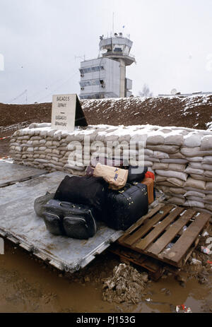 4 mars 1993 pendant le siège de Sarajevo : à l'aéroport de Sarajevo, de boue-éclaboussa des bagages est situé sur une palette humide avant d'être chargées à bord d'un avion des Nations Unies pour le court vol à Split en Croatie. Dans l'arrière-plan est la tour de contrôle. Banque D'Images