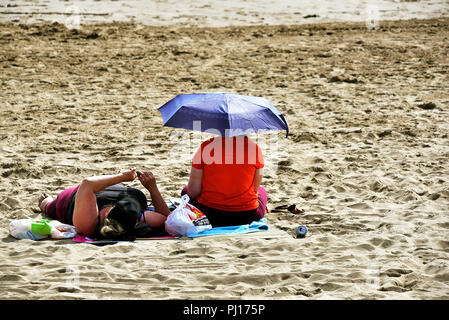 Barry Island, Vale of Glamorgan, Pays de Galles du Sud est une station balnéaire populaire attraction touristique. Sur la photo à la fin de l'été profiter du soleil 2018 . Whitmore Bay pic. Banque D'Images