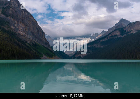 Le brouillard sort le mont Victoria et le ciel devient bleu sur le lac Louise à Banff, Canada. Banque D'Images