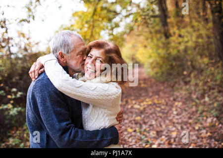 A senior couple hugging in un automne nature, s'embrasser. Copier l'espace. Banque D'Images