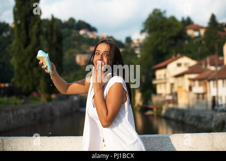 Femme tenant un melting ice-cream Banque D'Images