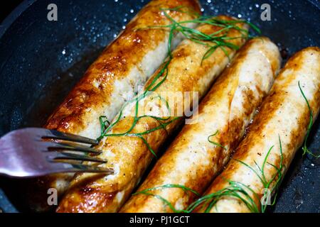 Quelques frites, saucisses fraîche et parfumée, se situent sur une poêle noir et fry. Elles sont décorées avec de l'aneth frais et utile. Très bonne nourriture à partir de la natur Banque D'Images