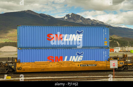 Les conteneurs empilés deux l'une sur l'autre wagon dans un train qui traverse Jasper en Alberta, Canada. Banque D'Images